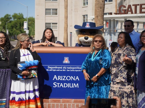 San Carlos Apache Members in front of Arizona Stadium Sign